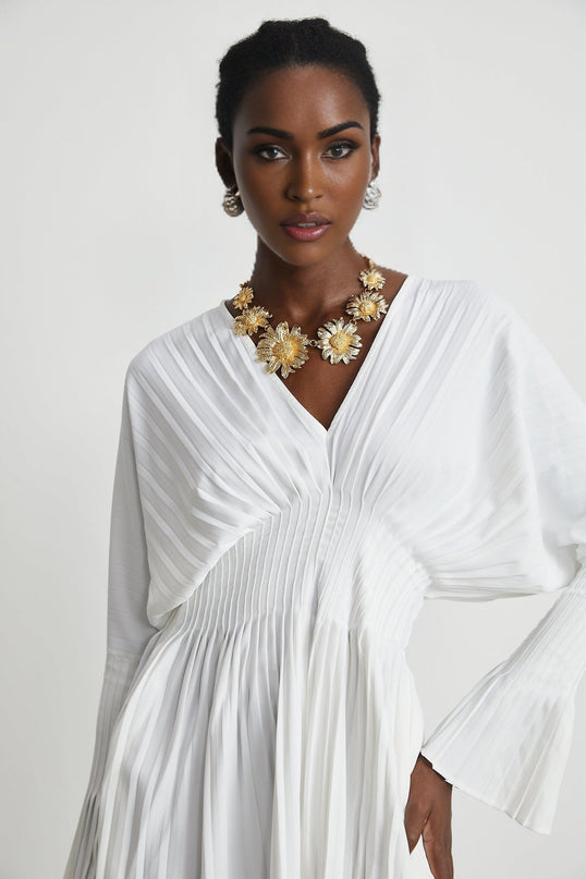 Claudette White Pleated Mini Dress V-neckline Flared Pleated Cuffs Long Sleeves Textured Finish Lacing Detail Waist Polyester Cotton Blend Light Airy Elegant Daywear Summer Occasions Chic Gatherings Flowy Mini Length Versatile Timeless