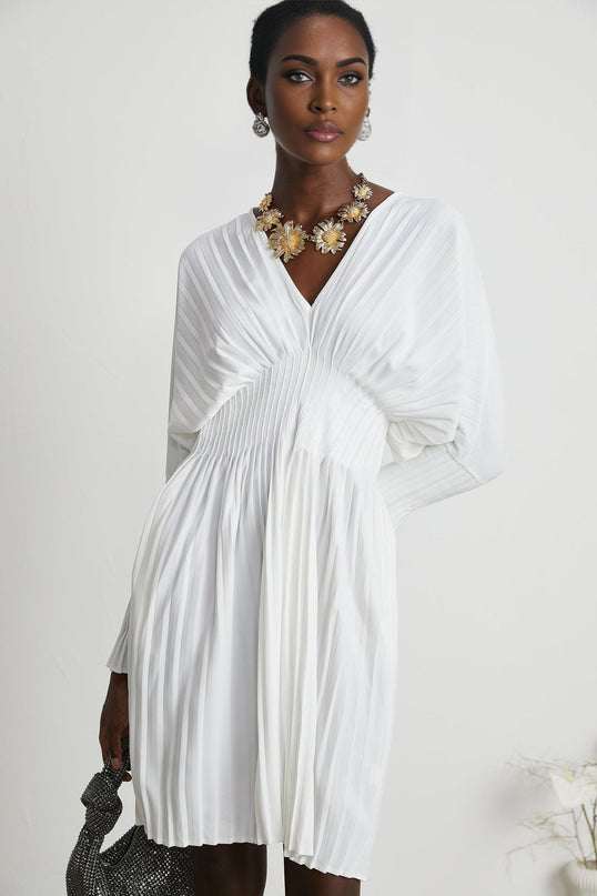 Claudette White Pleated Mini Dress V-neckline Flared Cuffs Long Sleeves Textured Finish Lacing Detail Waist Polyester Cotton Blend Light Airy Elegant Summer Chic Gatherings Flowy Mini Length Versatile Timeless