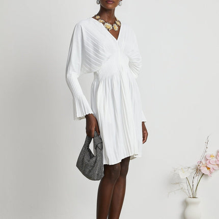Claudette White Pleated Mini Dress V-neckline Flared Cuffs Long Sleeves Textured Finish Lacing Detail Waist Blend Polyester Cotton Light Airy Elegant Summer Chic Gatherings Flowy Mini Length Timeless Piece