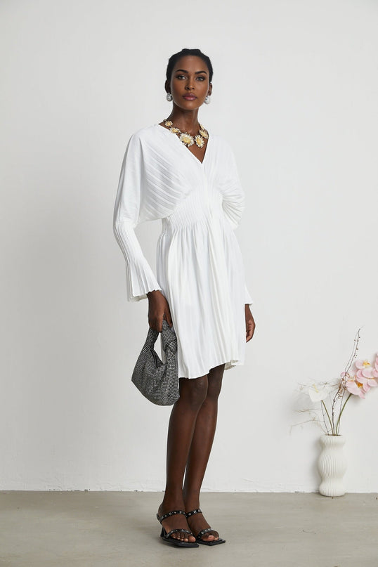 Claudette White Pleated Mini Dress V-neckline Flared Cuffs Long Sleeves Textured Finish Lacing Detail Waist Blend Polyester Cotton Light Airy Elegant Summer Chic Gatherings Flowy Mini Length Timeless Piece