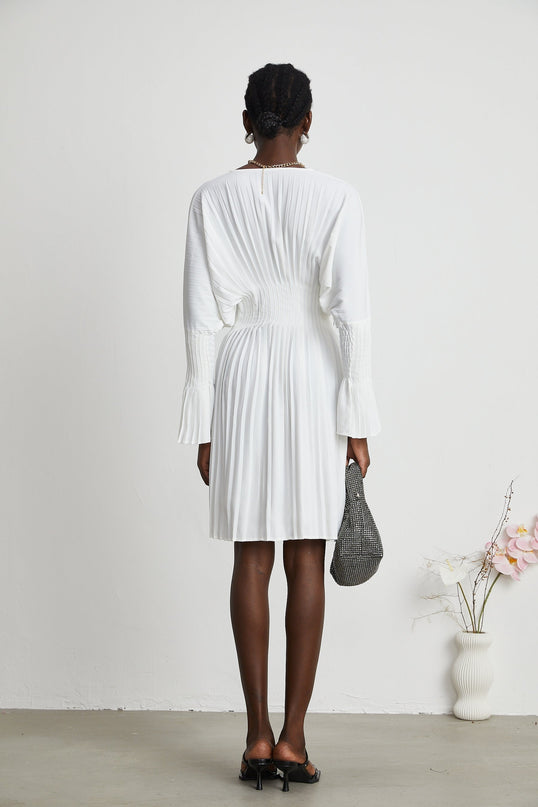 Claudette White Pleated Mini Dress V-neckline Flared Cuffs Long Sleeves Textured Finish Lacing Detail Waist Polyester Cotton Light Airy Elegant Summer Chic Versatile Timeless