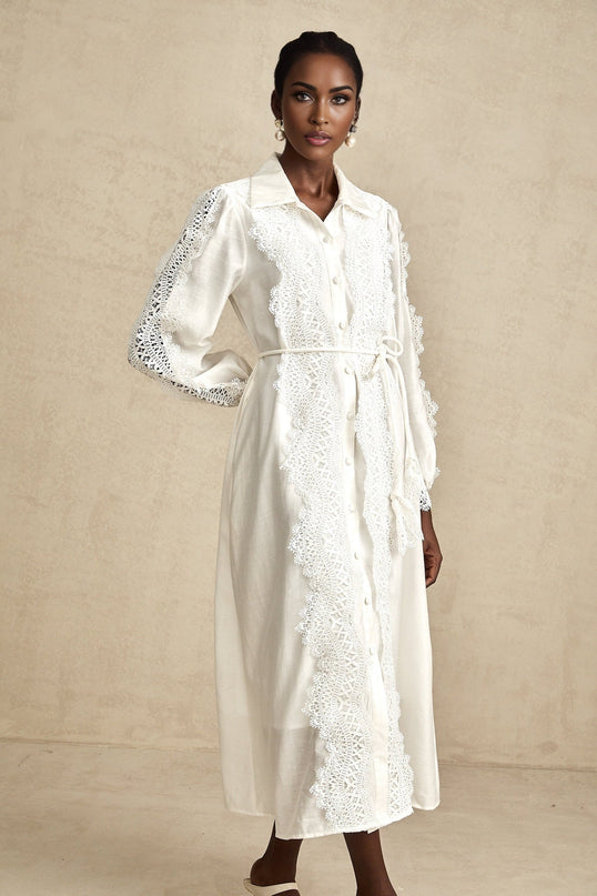 Colette white midi dress with lace details and tied waist on a model against a plain background