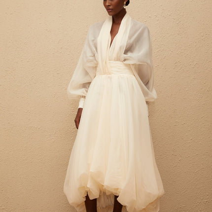 Daniela Maxi Dress in Cream White with V-neck, long puff sleeves, cinched waist, tulle fabric, draped design, and bubble hem