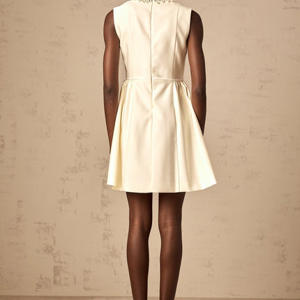 Delizia Mini Dress in Ivory White with Faux-pearl embellishment Sleeveless Bowknot Pleat Flared skirt Crew neck Rear zip fastening Thigh-length 41% Elastane 38% Cotton 12% Acetate 9% Wool