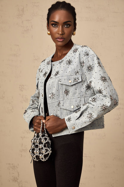 Denim jacket in blue with studded sun design and decorative elements on front