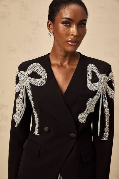 Elegant black blazer with bow motif embellishments adorning the design