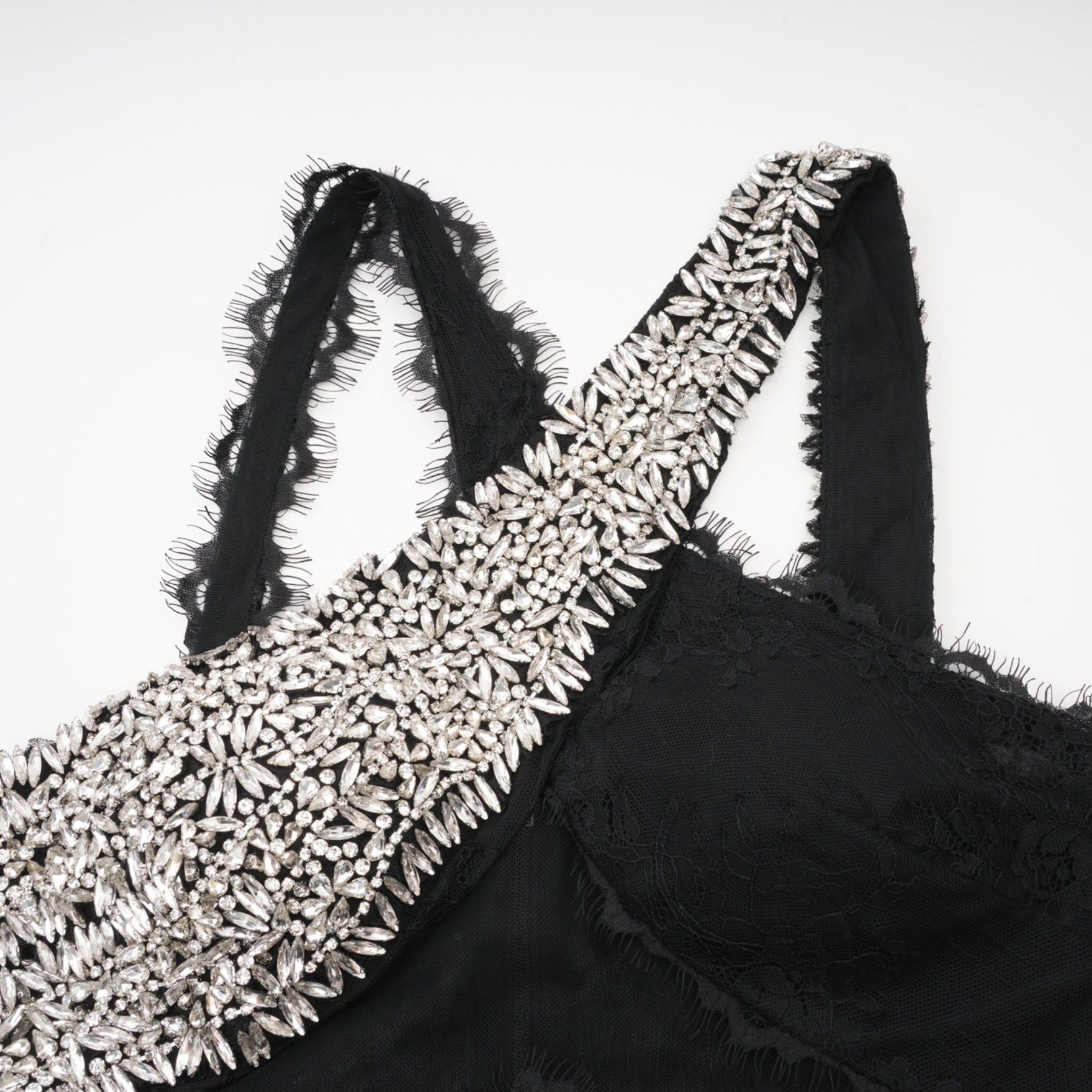 Black floorlength dress with lace overlay sleeveless crystal embellishment and crossover asymmetrical design showcasing a rear zip fastening