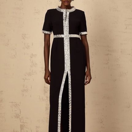 Elegant black maxi dress with front slit and crystal embellishments worn by model on plain background