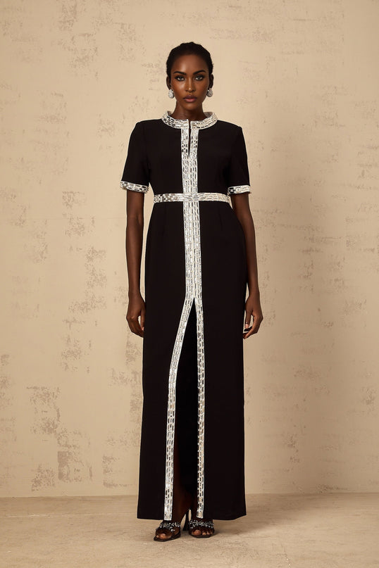 Elegant black maxi dress with front slit and crystal embellishments worn by model on plain background