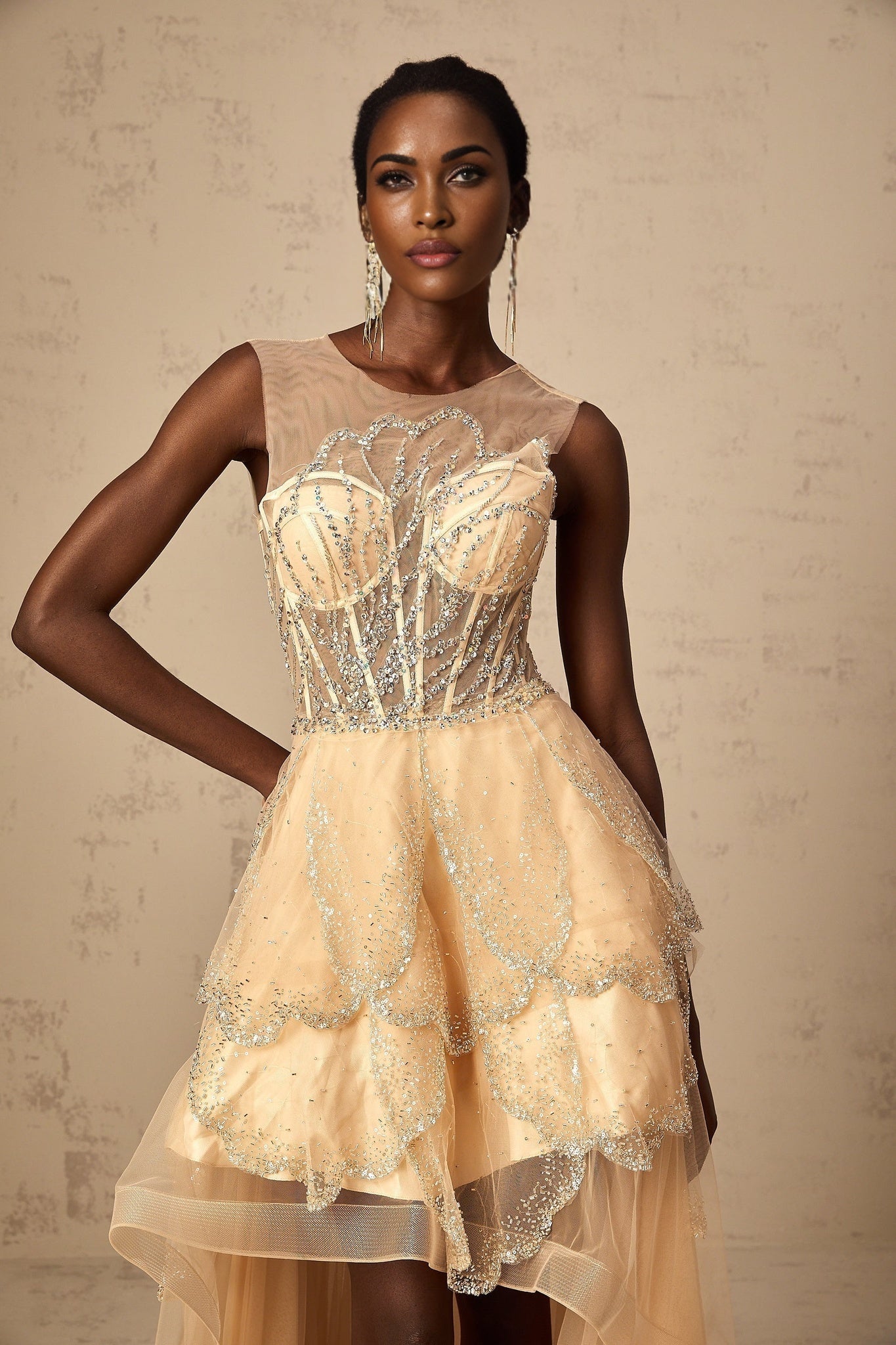 Elegant champagnecolored gown with daisy embellishments and highlow hemline