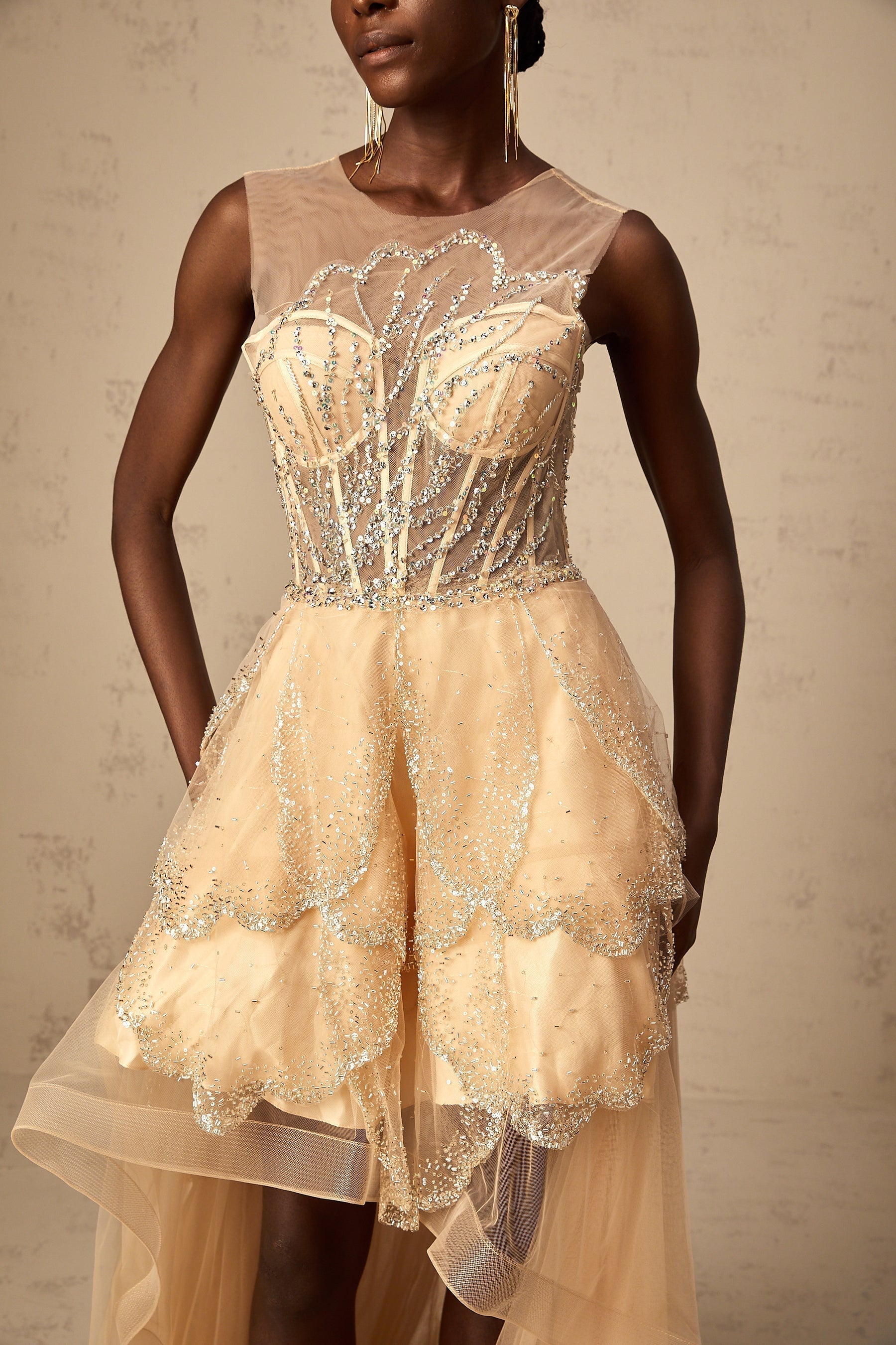 Elegant champagnecolored gown with daisy embellishments and highlow hemline