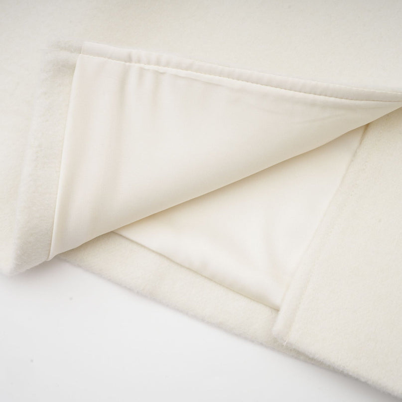 Elegant white jacket with cape design featuring intricate embellishments and beadwork on shoulders and sleeves