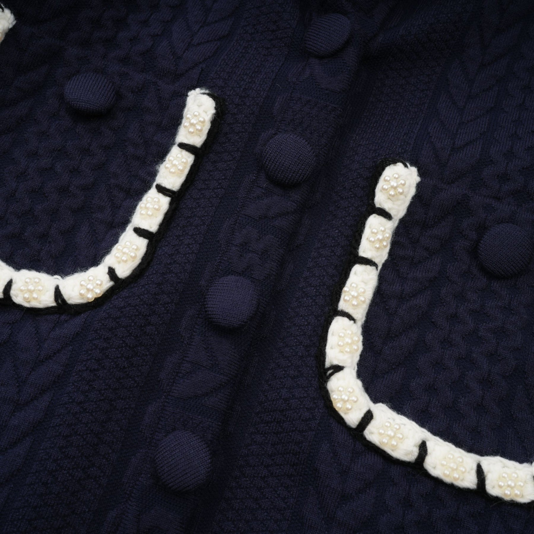 Elvira matching set featuring navy blue crochet knit cardigan and trousers worn by model against plain background