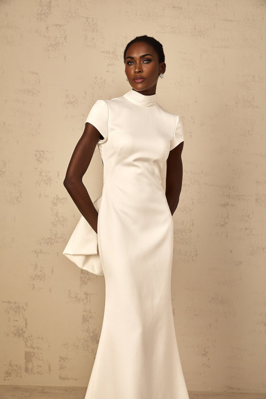 Emanuela White Maxi Dress with Mock Neck Cap Sleeves Open Back Fitted Waistline Boned Bodice Oversize-Bow Mermaid Hem Rear Clasp Zip Fastening 100% Terylene Fiber