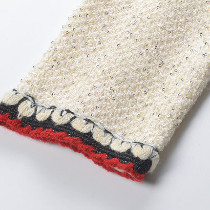 Elegant cream tweed jacket with red and black embroidery, decorative buttons, and a tailored fit