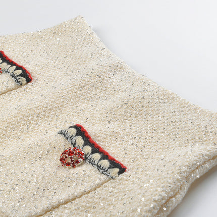 Elegant cream tweed jacket with red and black embroidery, decorative buttons, and a tailored fit