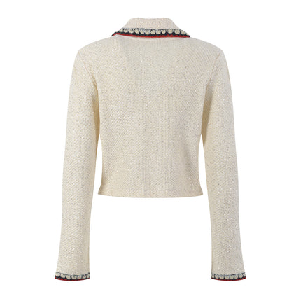 Elegant cream tweed jacket with red and black embroidery, decorative buttons, and a tailored fit