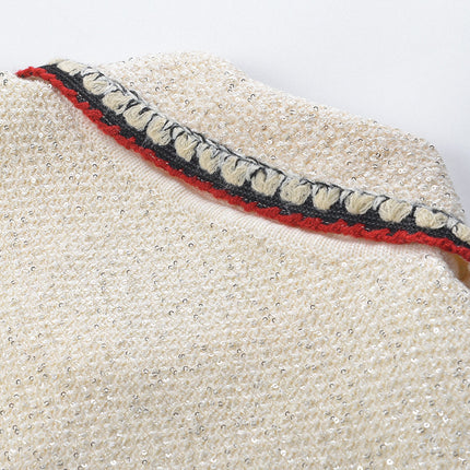 Elegant cream tweed jacket with red and black embroidery, decorative buttons, and a tailored fit