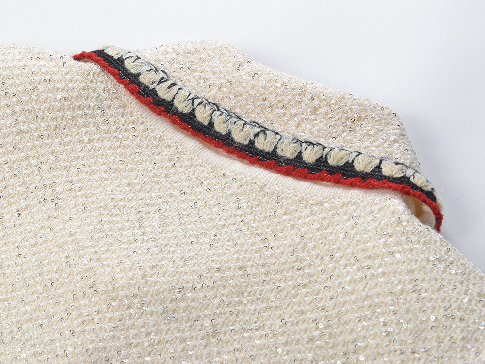 Elegant cream tweed jacket with red and black embroidery, decorative buttons, and a tailored fit