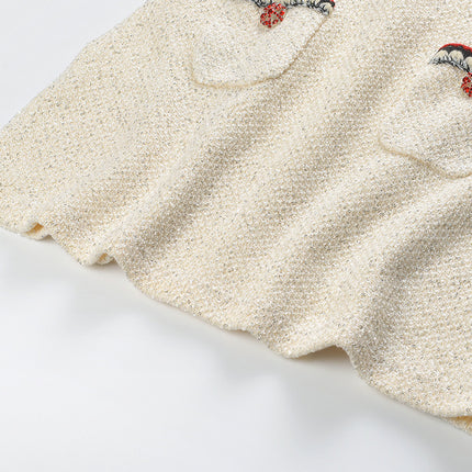 Elegant cream tweed jacket with red and black embroidery, decorative buttons, and a tailored fit