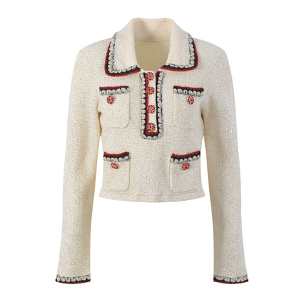 Elegant cream tweed jacket with red and black embroidery, decorative buttons, and a tailored fit