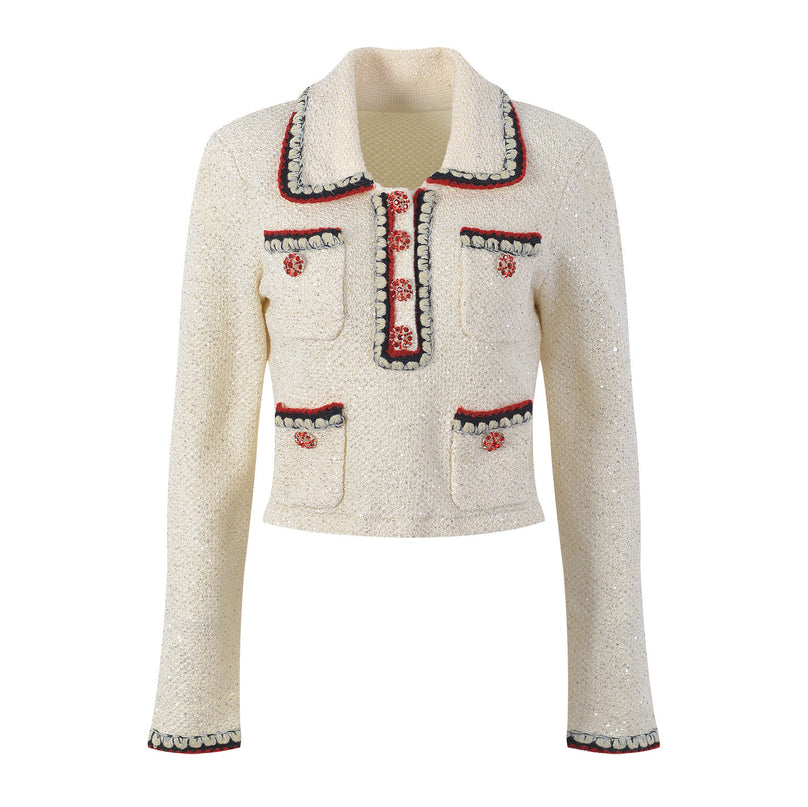 Elegant cream tweed jacket with red and black embroidery, decorative buttons, and a tailored fit