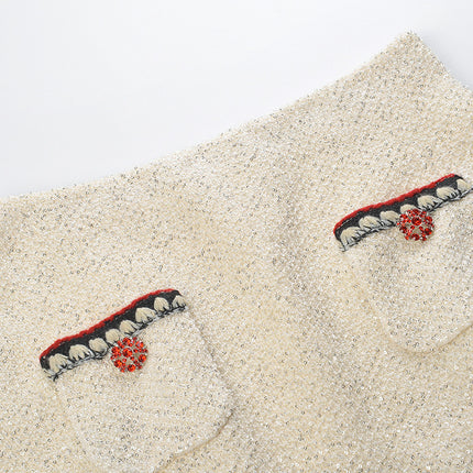 Elegant cream tweed jacket with red and black embroidery, decorative buttons, and a tailored fit