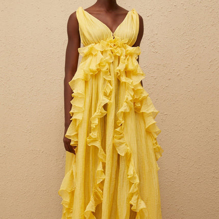 Emilia Yellow Maxi Dress V-neck sleeveless open back crinkled ruffled layered asymmetrical hem fitted waistline tassel detail 100% Terylene fiber glamour