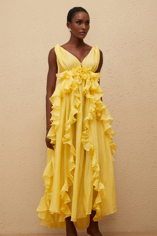 Emilia Yellow Maxi Dress V-neck sleeveless open back crinkled ruffled layered asymmetrical hem fitted waistline tassel detail 100% Terylene fiber glamour