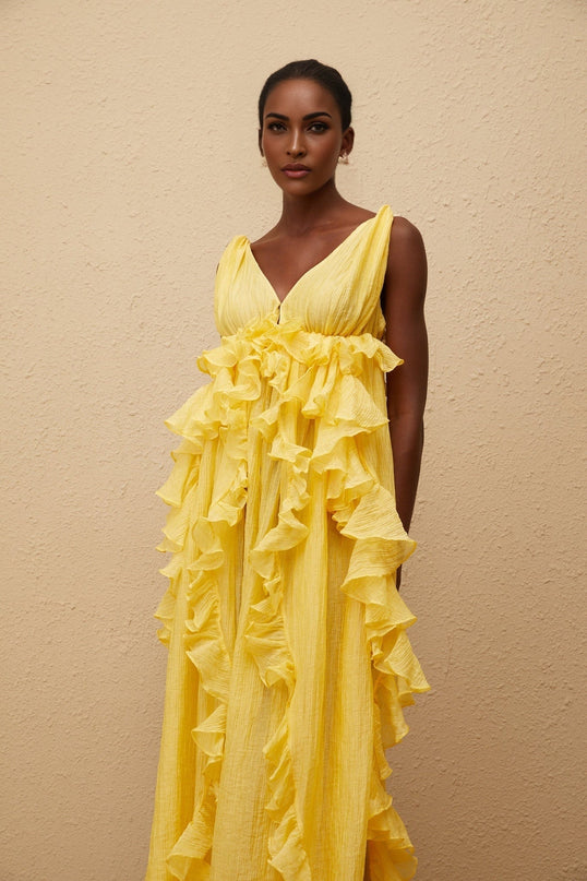 Emilia Yellow Maxi Dress V-neck Sleeveless Open Back Crinkled Ruffled Layered Asymmetrical Hem Fitted Waistline Tassel Detail 100% Terylene Fiber Glamour