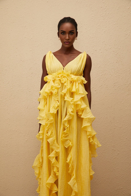 Emilia Yellow Maxi Dress V-neck Sleeveless Open Back Crinkled Ruffled Layered Asymmetrical Hem Fitted Waistline Tassel Detail 100% Terylene Fiber