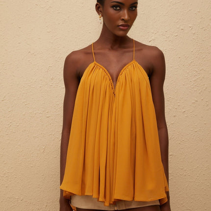 Emily wearing Nemesis Ginger Pleated Chiffon Top in Orange color