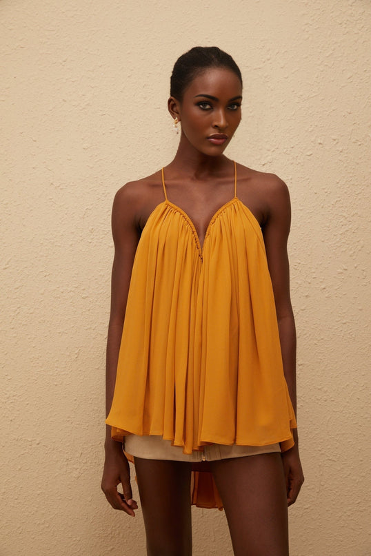 Emily wearing Nemesis Ginger Pleated Chiffon Top in Orange color