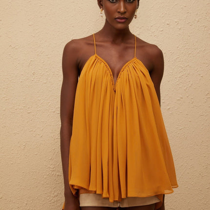 Emily wearing Nemesis Ginger Pleated Chiffon Top in Orange