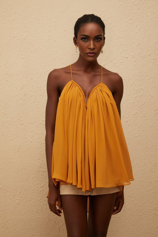 Emily wearing Nemesis Ginger Pleated Chiffon Top in Orange