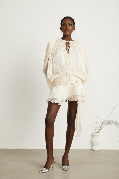 Eugenie pleated ruffled mini dress in neutral color with voluminous skirt and short length