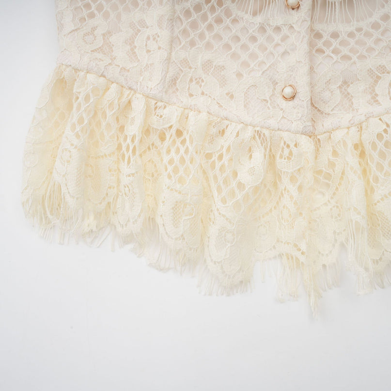 Feminine offwhite blouse with delicate floral lace pattern and a decorative bowknot detail at the neckline