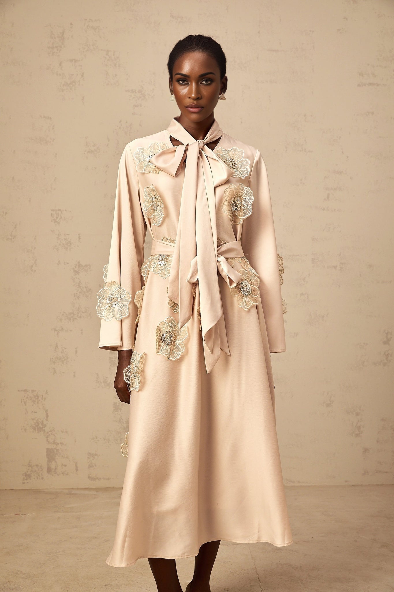 Flared midi dress in neutral tones with tied waist and floral applique details