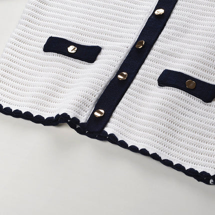 White knit cardigan with navy accents and gold buttons paired with a matching A-line skirt featuring a flared hem