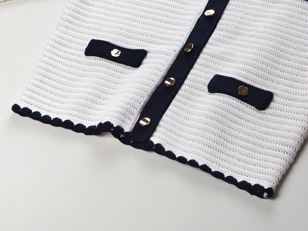 White knit cardigan with navy accents and gold buttons paired with a matching A-line skirt featuring a flared hem