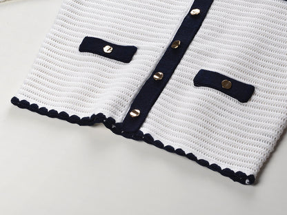 White knit cardigan with navy accents and gold buttons paired with a matching A-line skirt featuring a flared hem