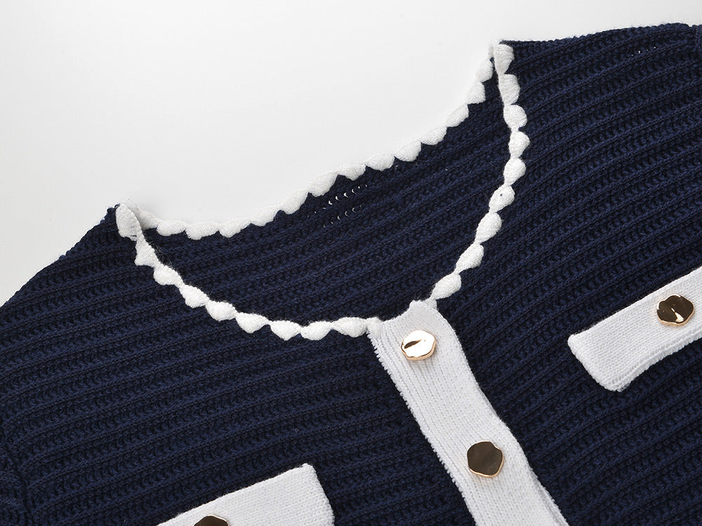 White knit cardigan with navy accents and gold buttons paired with a matching A-line skirt featuring a flared hem