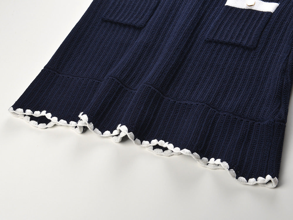White knit cardigan with navy accents and gold buttons paired with a matching A-line skirt featuring a flared hem