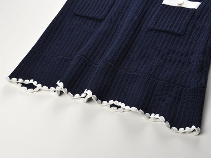 White knit cardigan with navy accents and gold buttons paired with a matching A-line skirt featuring a flared hem