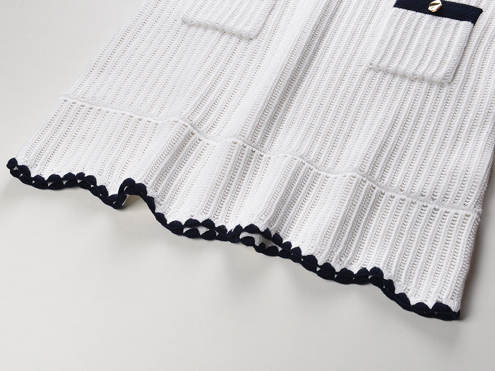 White knit cardigan with navy accents and gold buttons paired with a matching A-line skirt featuring a flared hem