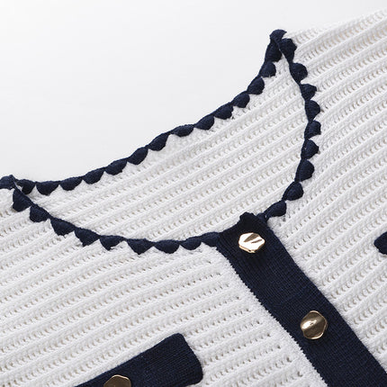 White knit cardigan with navy accents and gold buttons paired with a matching A-line skirt featuring a flared hem
