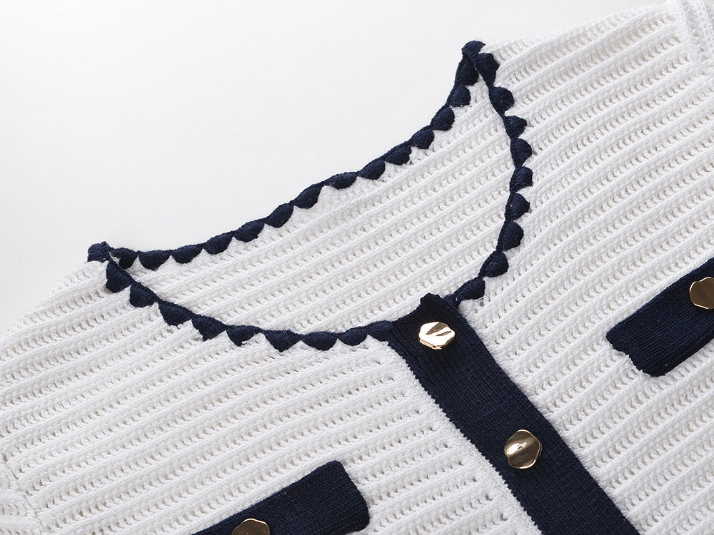 White knit cardigan with navy accents and gold buttons paired with a matching A-line skirt featuring a flared hem