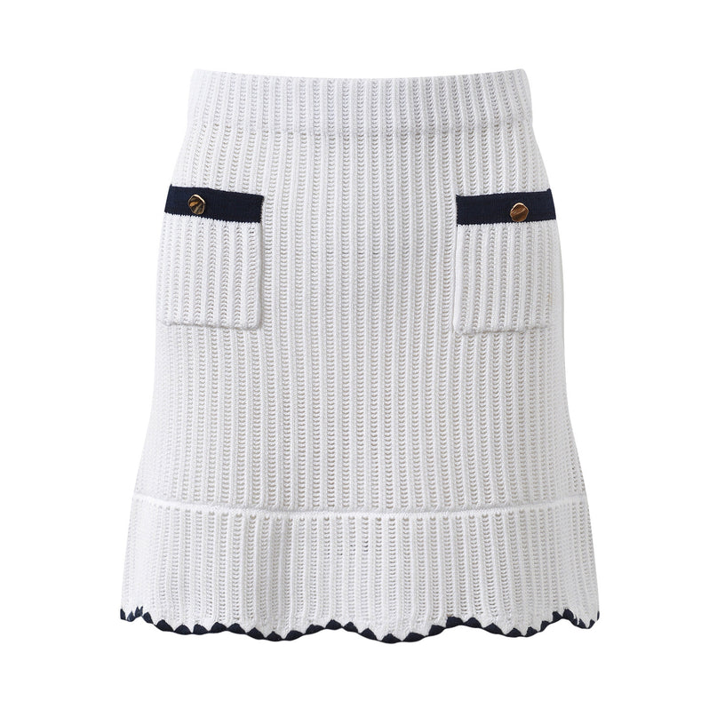 White knit cardigan with navy accents and gold buttons paired with a matching A-line skirt featuring a flared hem