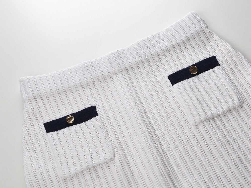 White knit cardigan with navy accents and gold buttons paired with a matching A-line skirt featuring a flared hem