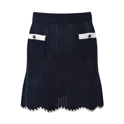 White knit cardigan with navy accents and gold buttons paired with a matching A-line skirt featuring a flared hem